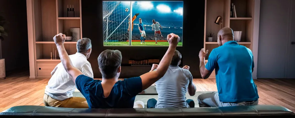 Homem assistindo futebol ao vivo em uma tela de TV com Grade de Canais IPTV Premiere